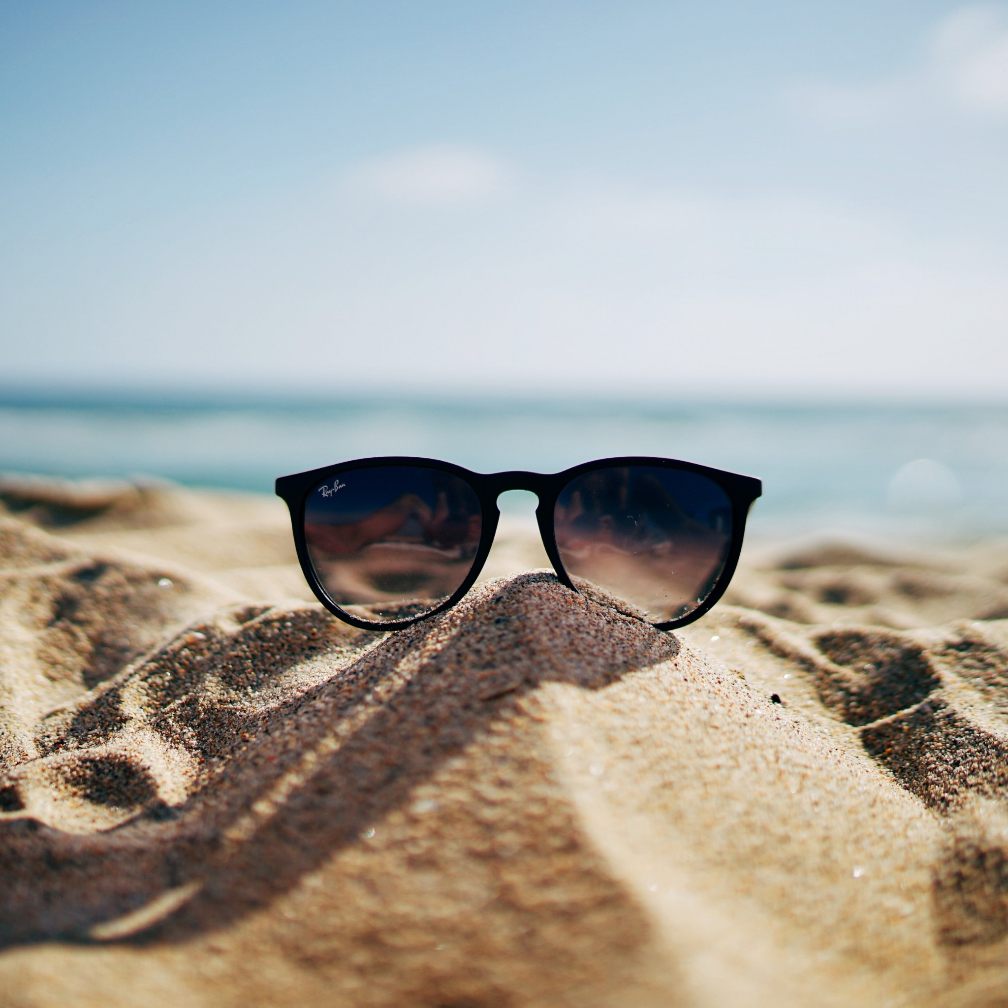 Ray Ban sunglasses on hot sand beach wallpaper 2048x2048