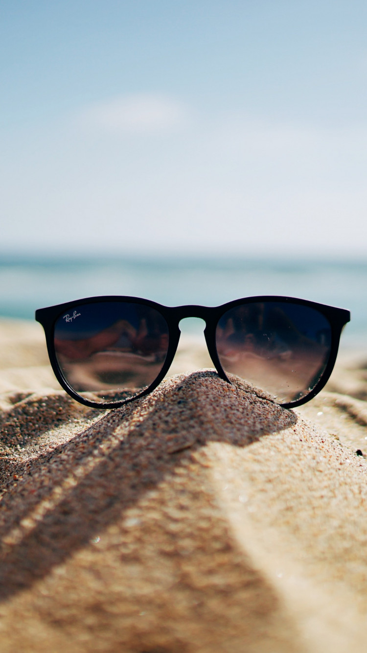 Ray Ban sunglasses on hot sand beach wallpaper 750x1334