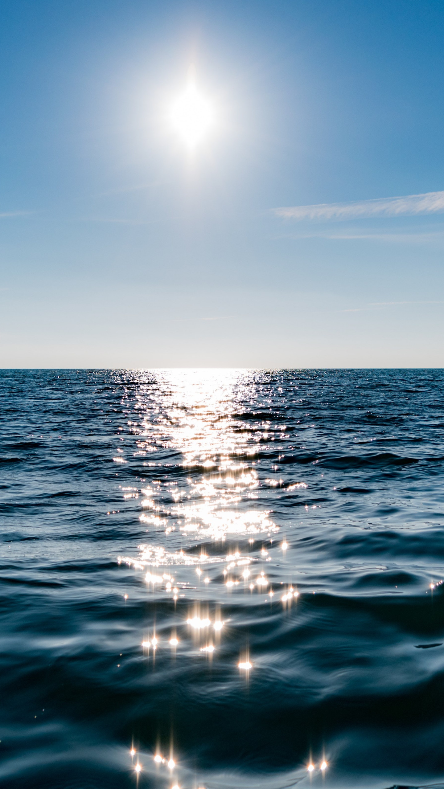 Sun on blue sky is reflected on water wallpaper 1440x2560