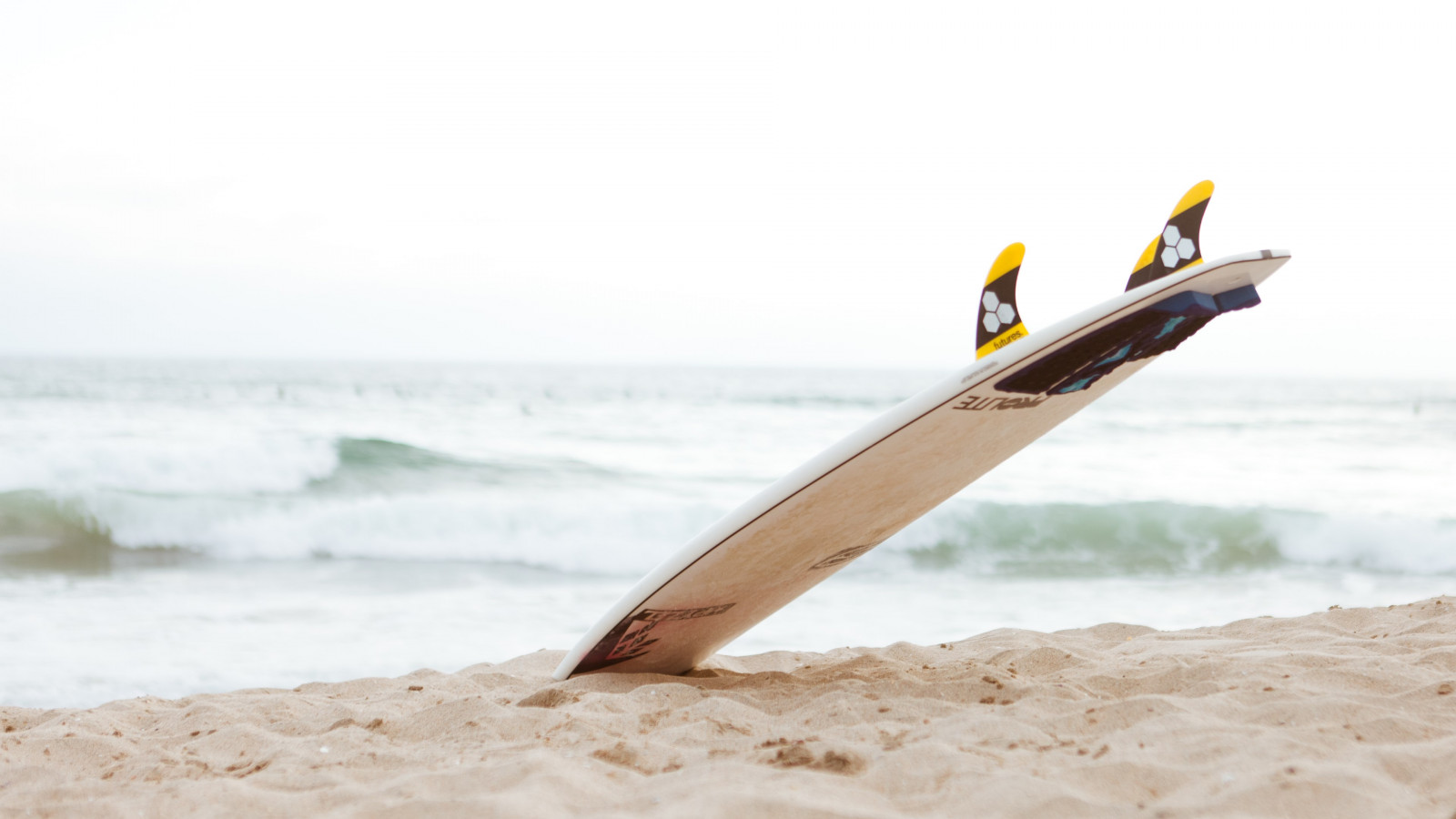 Surf board on the beach wallpaper 1600x900