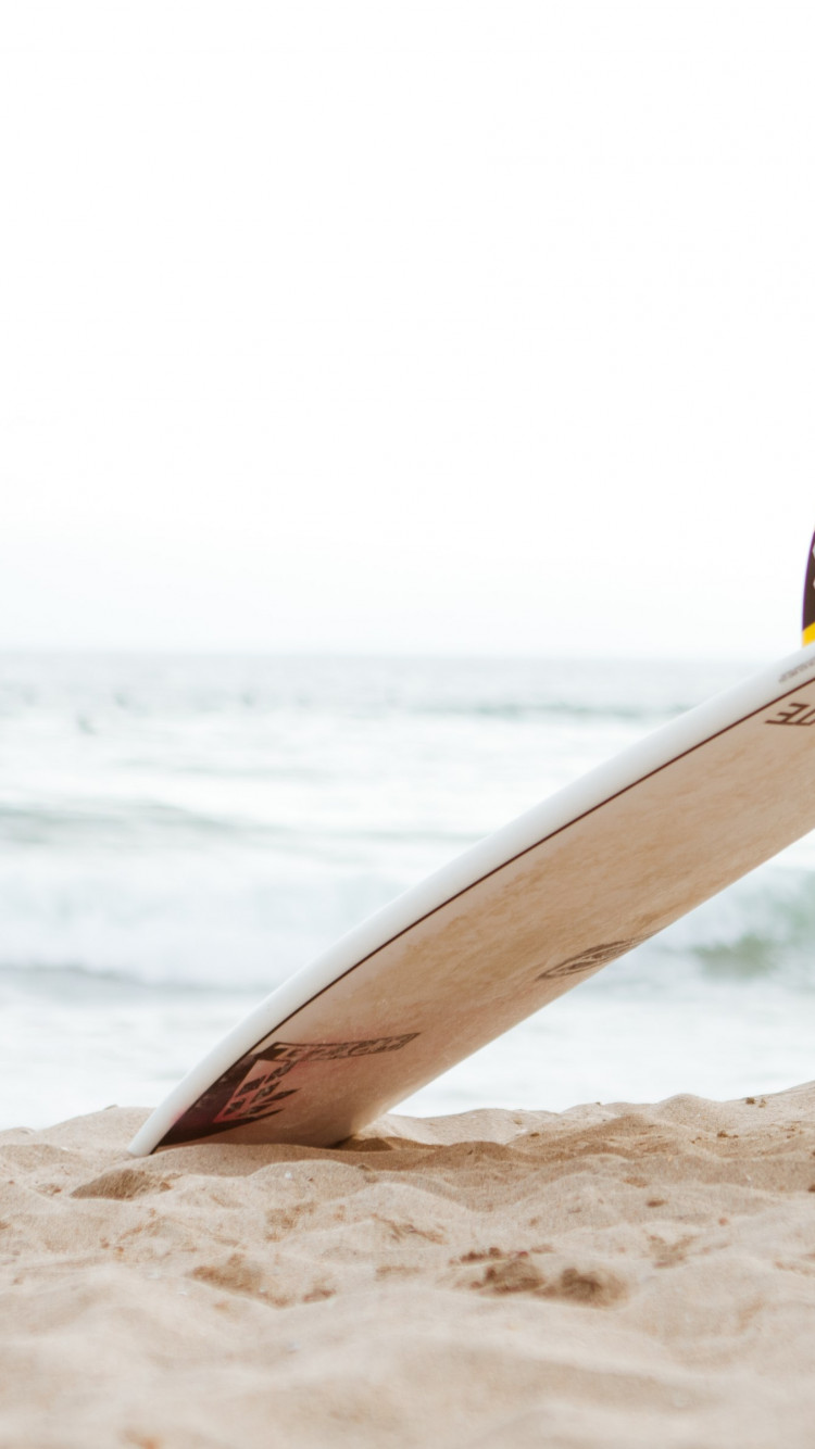 Surf board on the beach wallpaper 750x1334